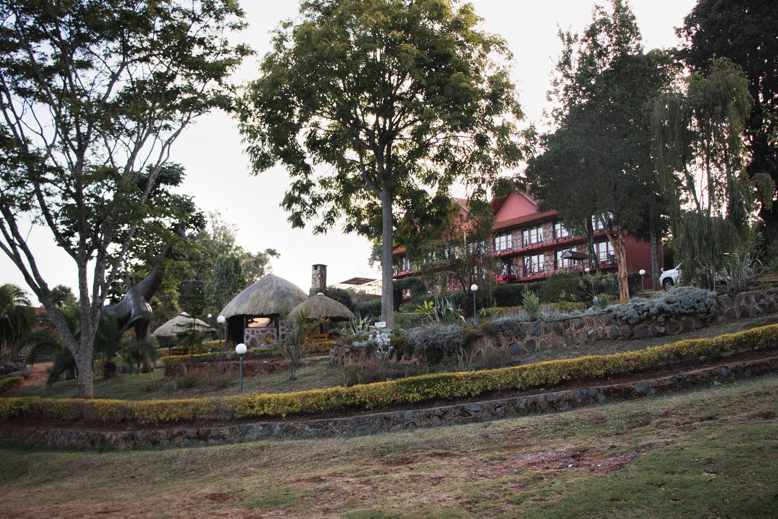 The Kerio View grounds, thatched bandas and old trees below the red-roofed main lodge