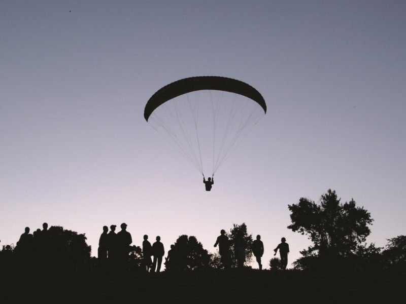 A paraglider silhouetted against the evening sky