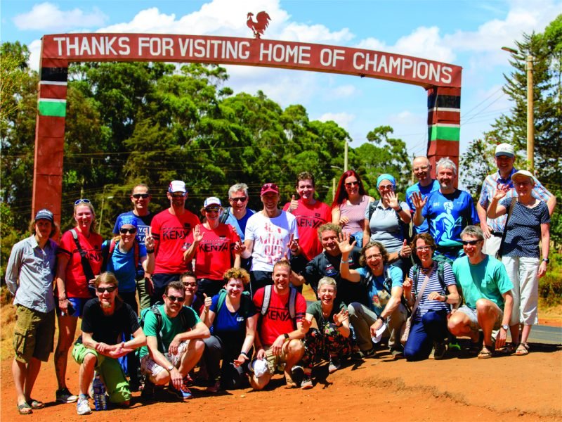 A group of visiting runners at the Home of Champions gate in Iten
